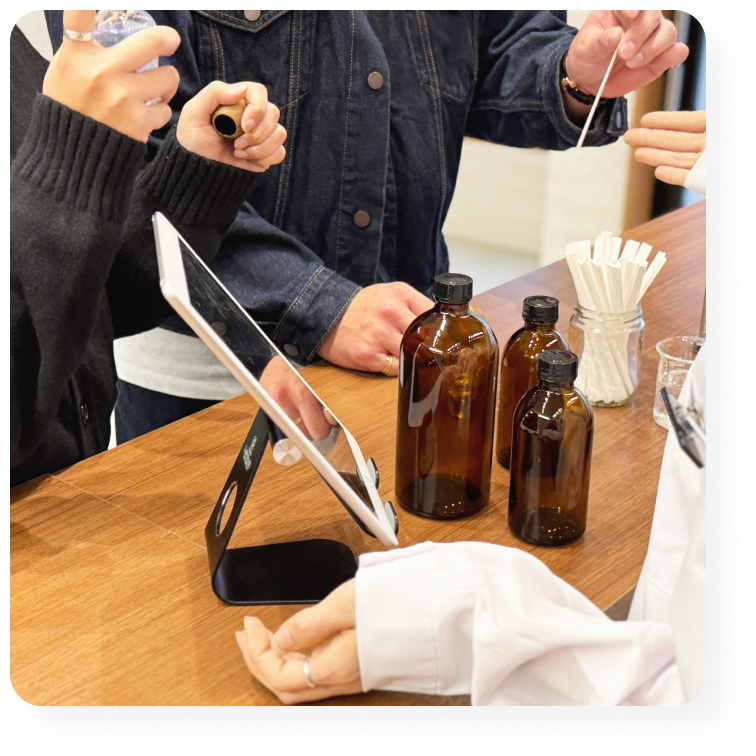 調香体験中のカウンター。スタッフと来店者が香料を選びながら香水を作っている様子。