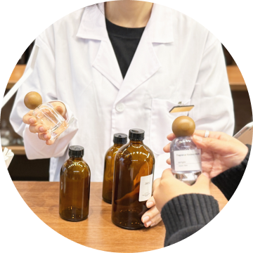 調香体験でスタッフが香料ボトルを手渡す様子。