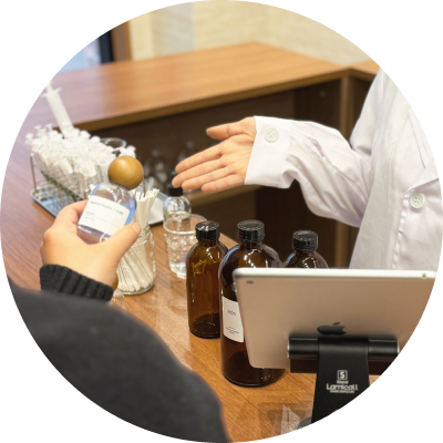 調香カウンターでスタッフが香りづくりを案内している様子。