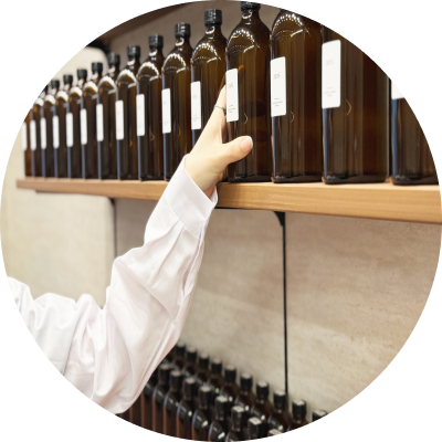 棚に並ぶ香料ボトルから香りを選ぶスタッフの手元。