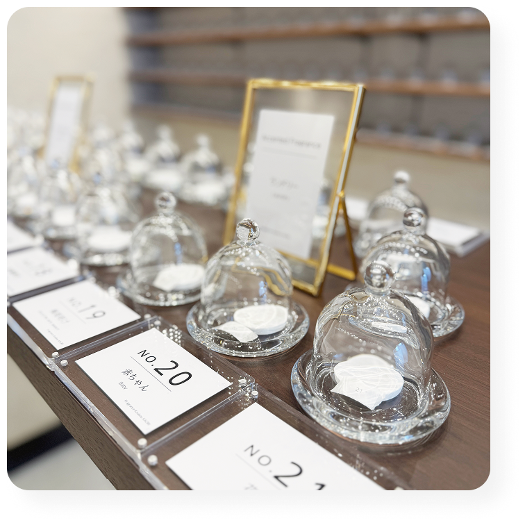 香りサンプルが並ぶテーブル。ガラスドームに入った香りの展示。