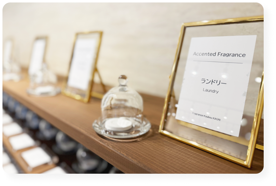 棚に並ぶ香りサンプルと「ランドリー」などの香名プレート。落ち着いた雰囲気の展示スペース。