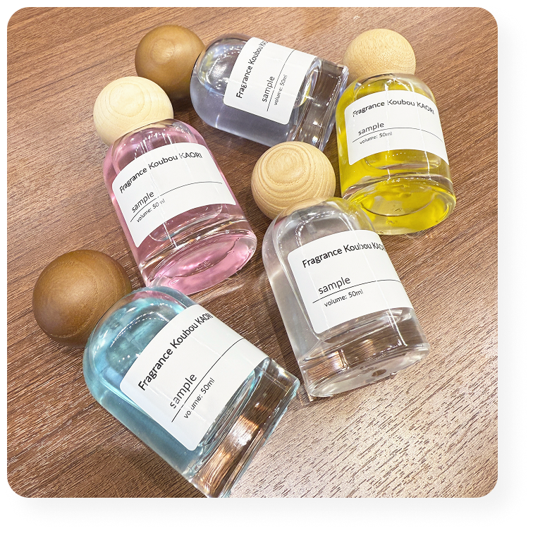 フレグランスボトルに詰められたカラフルな香水。木製キャップが印象的。