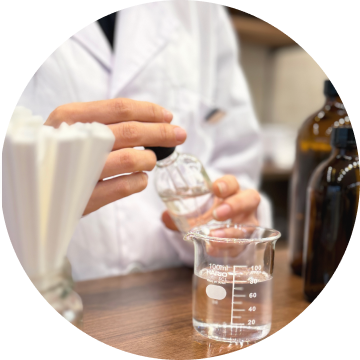 フレグランス工房「香」で香料をビーカーに注ぐ調香作業。