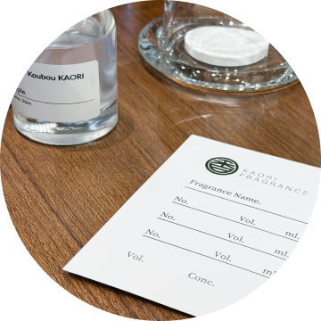 香りの配合メモとボトルが並ぶテーブル。香水作りの工程の一部。