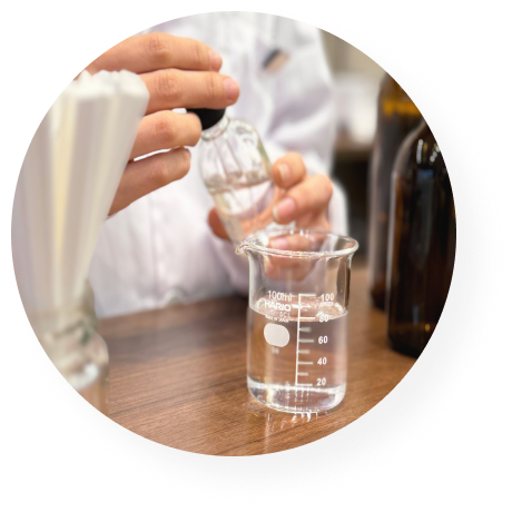 フレグランス作り体験でビーカーに香料を注ぐ様子。