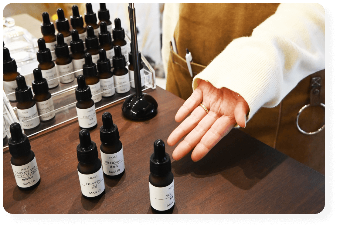 フレグランス工房「香」のに並ぶ香料の説明をしている様子。